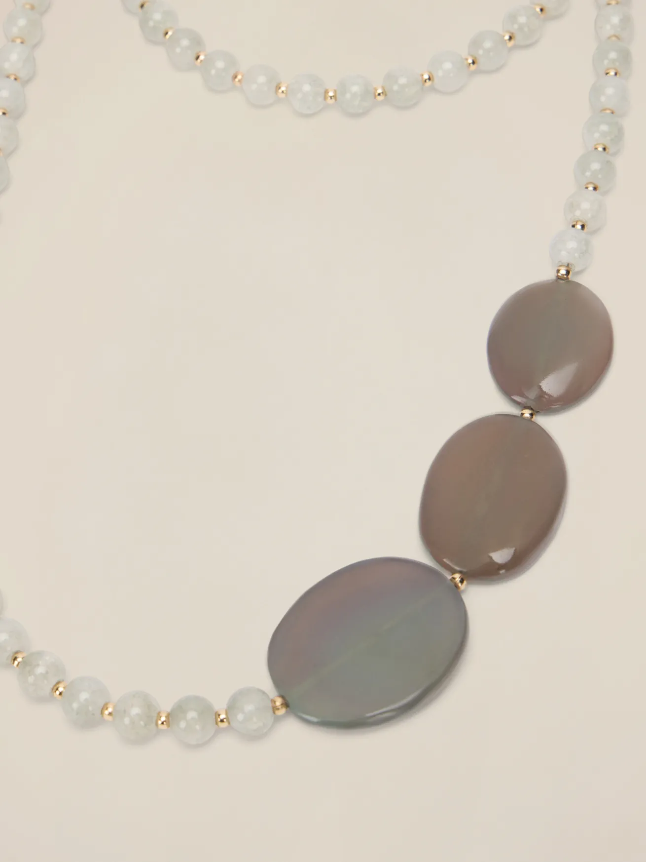 Collana lunga con perle ed elementi geometrici