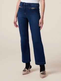 Jeans kick flare con fibbie metalliche